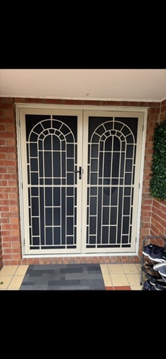 Cream double security doors with arched sunrise pattern