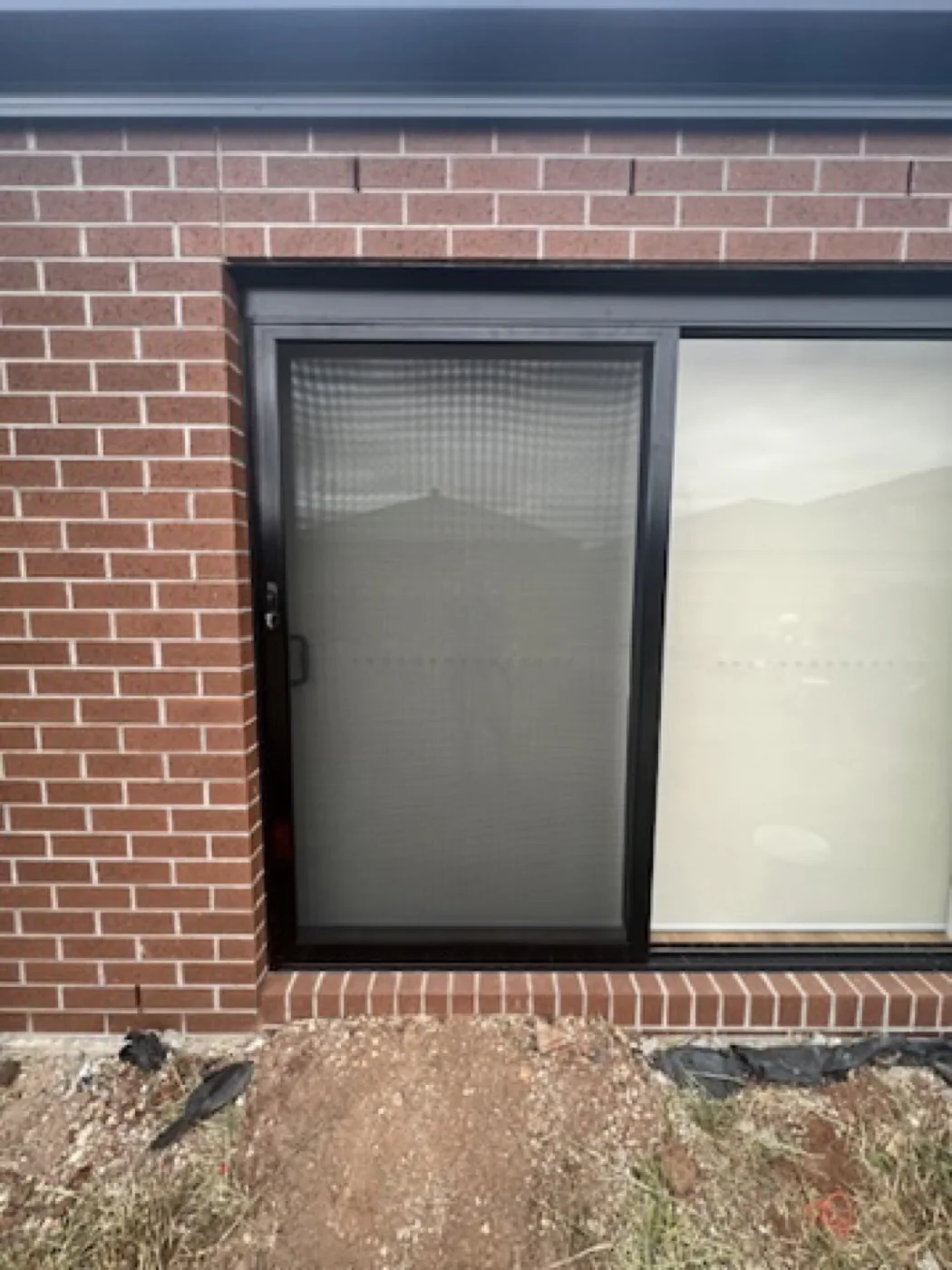 Black sliding security screen door installed on a new build home