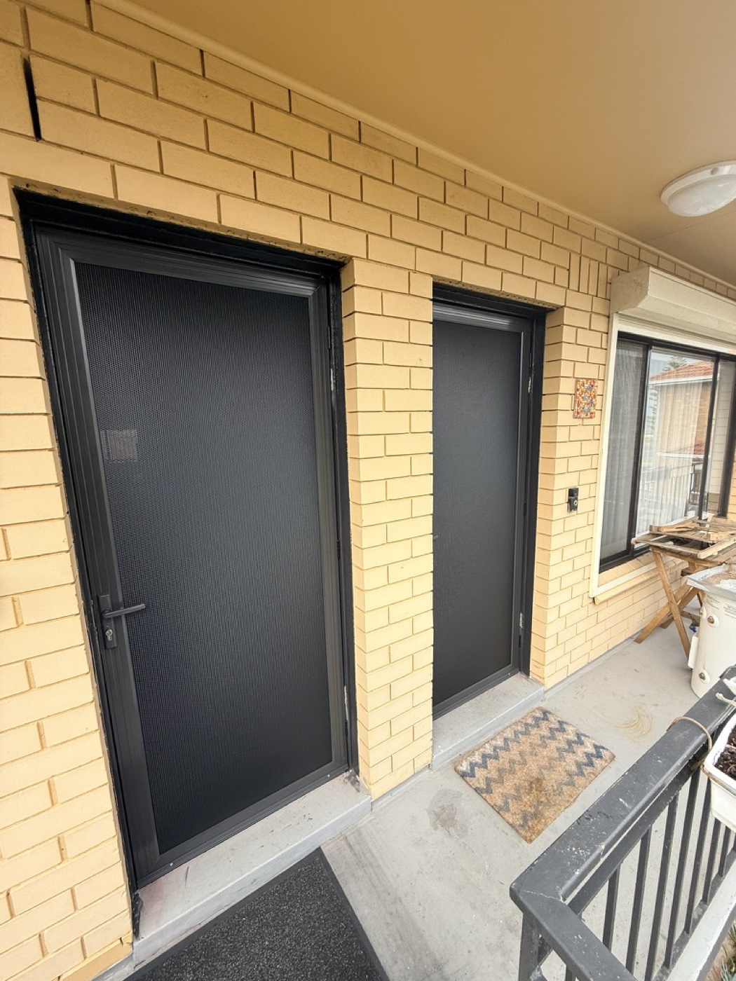 Matching black security doors on neighbouring unit entrances