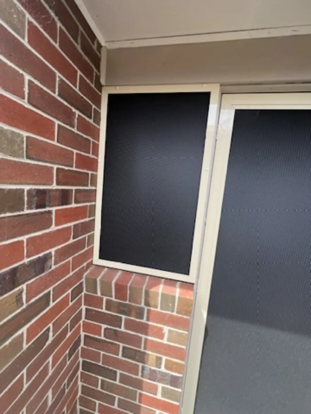 Colour-matched cream window security screen beside a sliding door