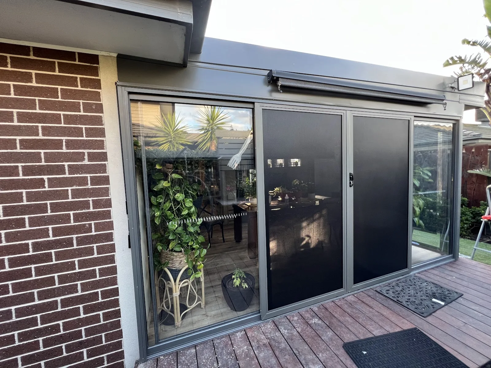 Black sliding security screen doors installed on a Melbourne alfresco