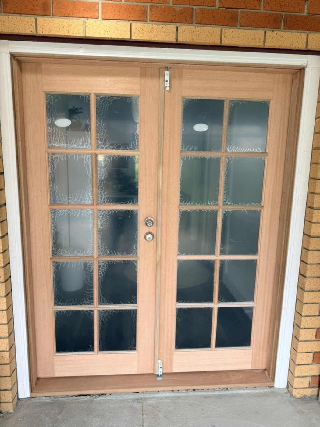 New double-hinged timber French doors with feature glass replacing an old aluminium door