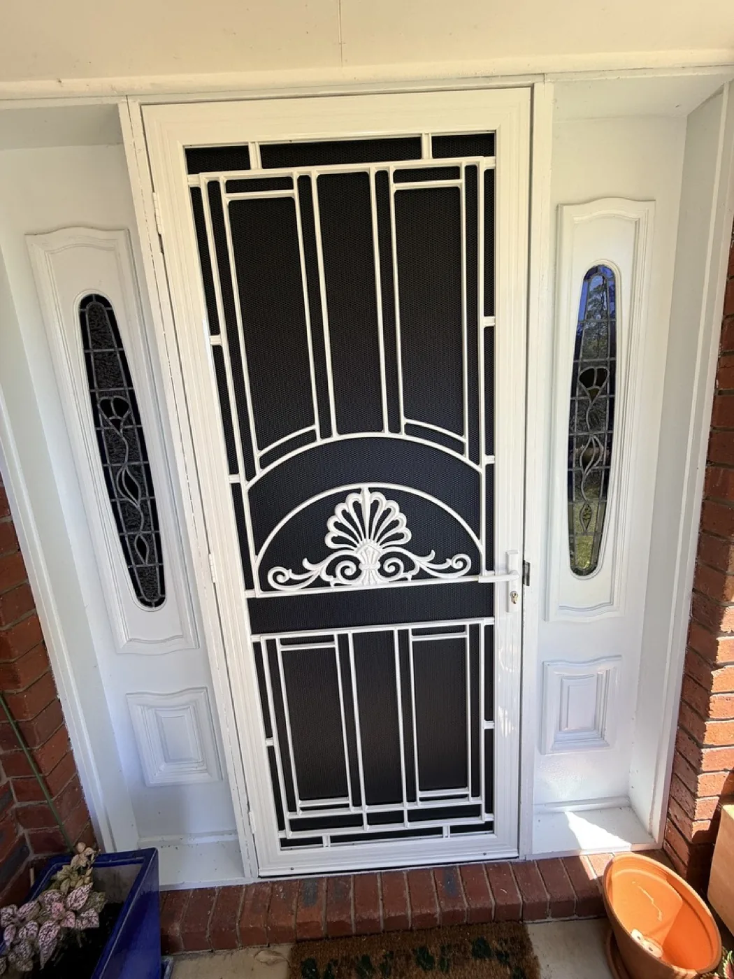Custom white cast iron security door with shell motif on a heritage Melbourne home